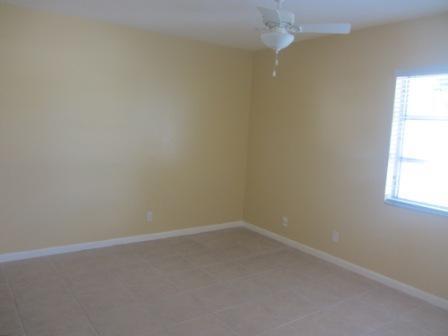 An empty bedroom with beige walls, tile flooring, and a ceiling fan — 626 NW 13th Street # 0280, Boca Raton FL 33486, BOCA RATON, FL