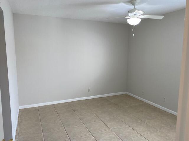 An empty room features light-colored walls, a ceiling fan, and large beige floor tiles — 626 NW 13th Street # 0280, Boca Raton FL 33486, BOCA RATON, FL