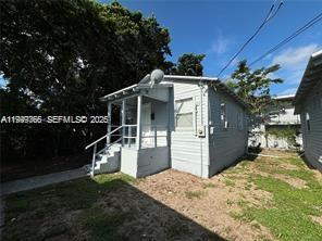 A small, light-gray, single-story house with a front porch and stairs sits on a lot — 820 21st St # C, West Palm Beach FL 33407, WEST PALM BEACH, FL
