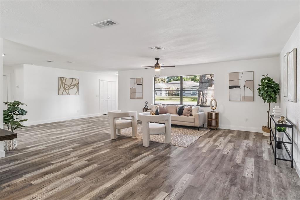 A living room features wood-look flooring, white walls, a ceiling fan, and modern furniture — 5170 ANDOVER STREET, COCOA, FL