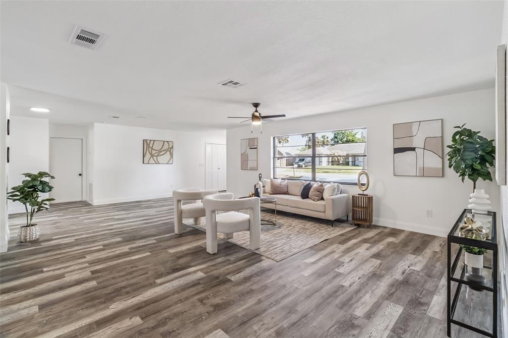 A living room features light gray wood-look flooring, white walls, and a modern seating area — 5170 ANDOVER STREET, COCOA, FL