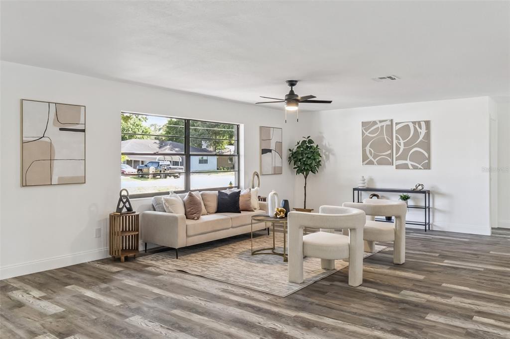 A living room features a sofa, two armchairs, a rug, and wood-look flooring — 5170 ANDOVER STREET, COCOA, FL