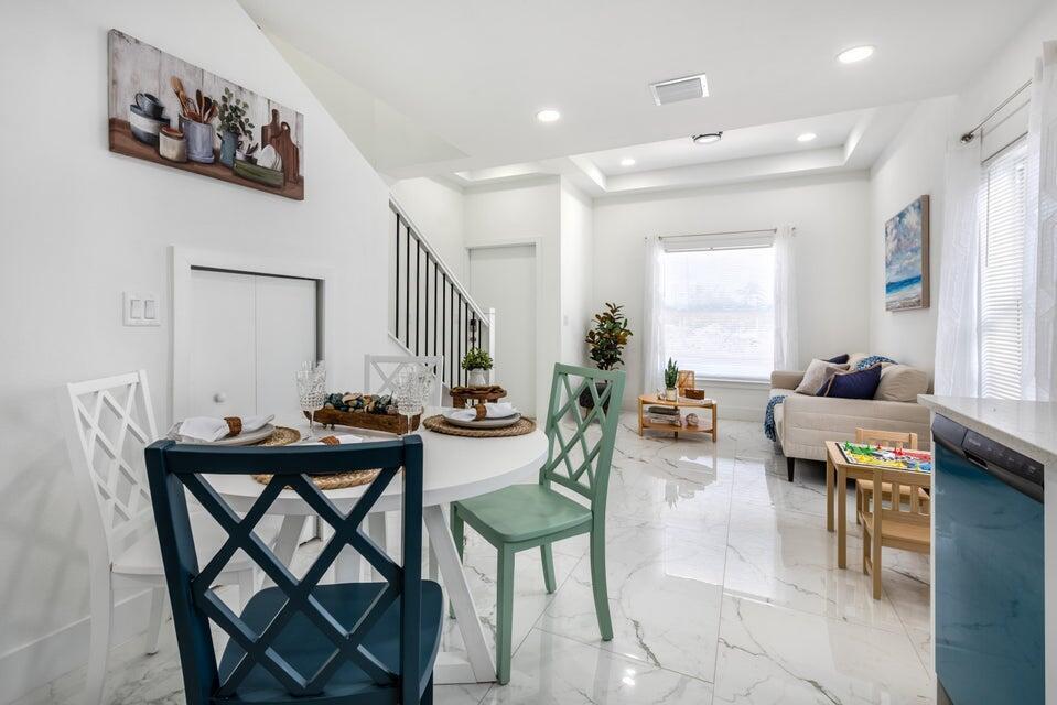 A dining area with a round table and chairs opens into a living room space — 432 NW 13th Avenue, Boynton Beach FL 33435, BOYNTON BEACH, FL