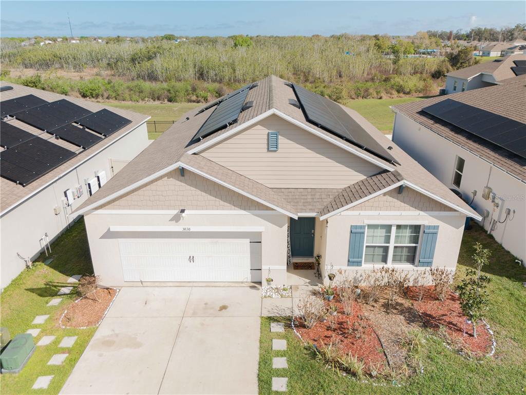 An aerial view of a single-story suburban house with solar panels on the roof — 3838 WHITNEY WAY, HAINES CITY, FL