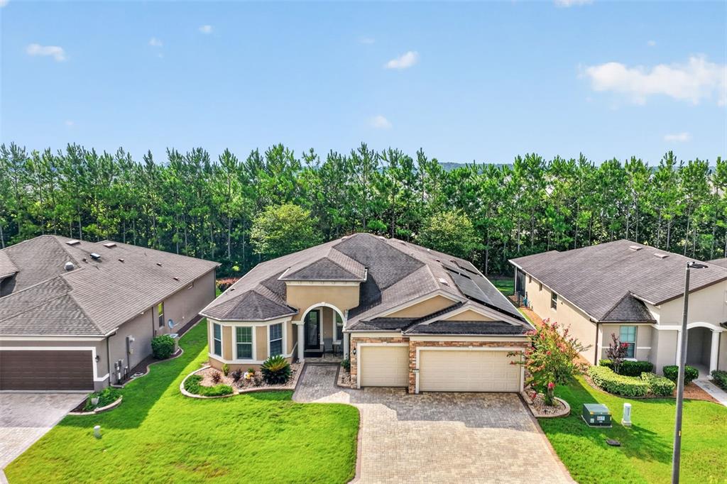 An aerial view shows a tan suburban house with a paved driveway and a grassy lawn — 9199 SW 70TH LOOP, OCALA, FL