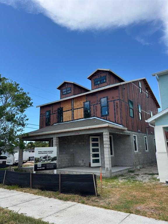 A three-story house under construction with exposed concrete blocks and brown sheathing panels — 6179 1ST AVENUE N, ST PETERSBURG, FL