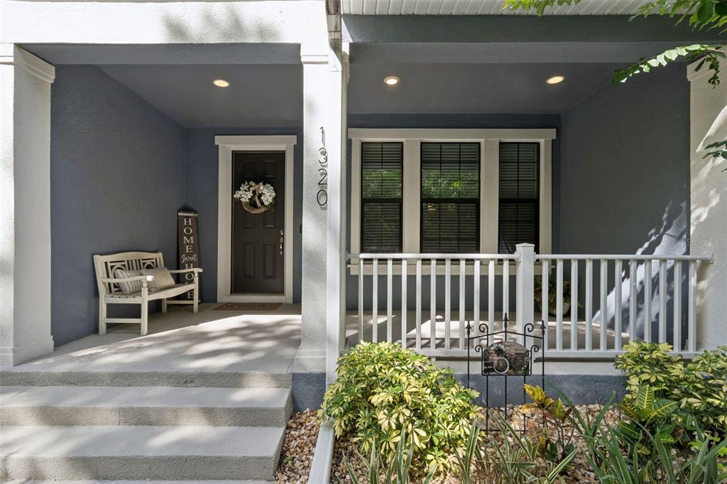 A front porch with a white bench, a dark door, and a white railing — 1320 SPOTTED SANDPIPER LOOP, WINTER SPRINGS, FL