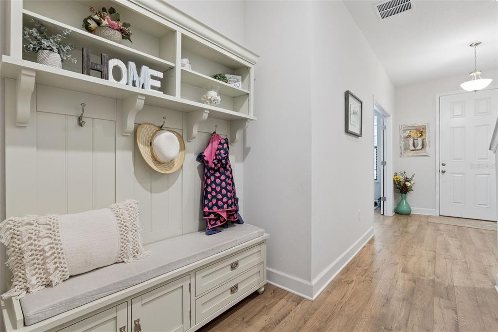 A mudroom entryway features a built-in bench with storage, coat hooks, and light wood flooring — 1320 SPOTTED SANDPIPER LOOP, WINTER SPRINGS, FL