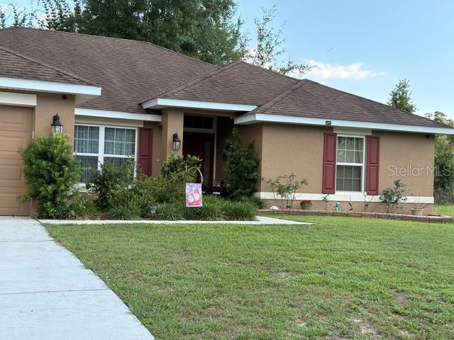 A single-story house with a brown roof, tan stucco exterior, and a concrete walkway — 8262 SE 158TH PLACE, SUMMERFIELD, FL