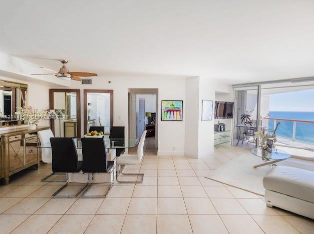 A bright, open-concept living and dining area features tile floors, a ceiling fan, and ocean views — 6767 Collins Ave # 1608, Miami Beach FL 33141, MIAMI BEACH, FL