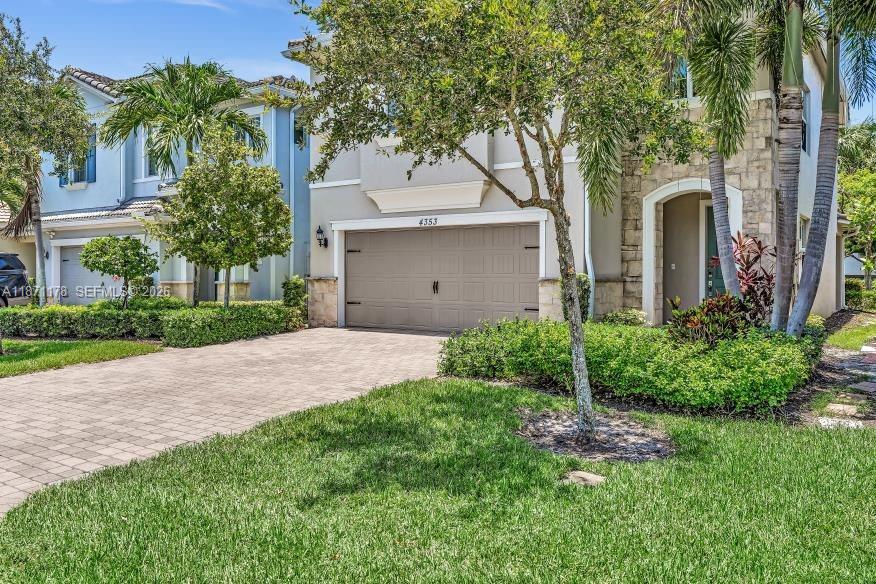 A two-story suburban house with a paved driveway, stone facade, and a two-car garage — 4353 Large Leaf Ln, Hollywood FL 33021, HOLLYWOOD, FL