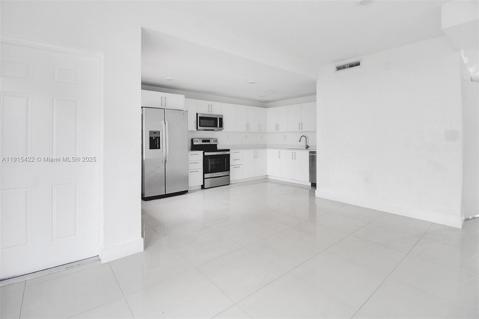 A kitchen with white cabinets, stainless steel appliances, and light-colored tile flooring — 14482 SW 259th St, Homestead FL 33032, HOMESTEAD, FL