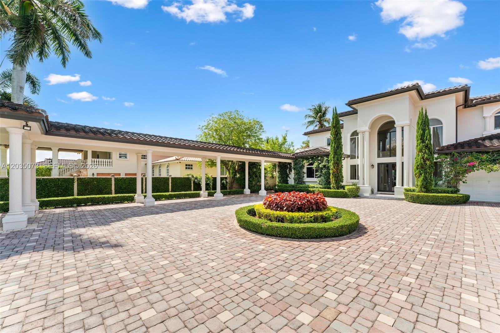 A large house with a paved circular driveway, a covered walkway, and manicured landscaping — 13470 SW 32nd St, Miami FL 33175, MIAMI, FL