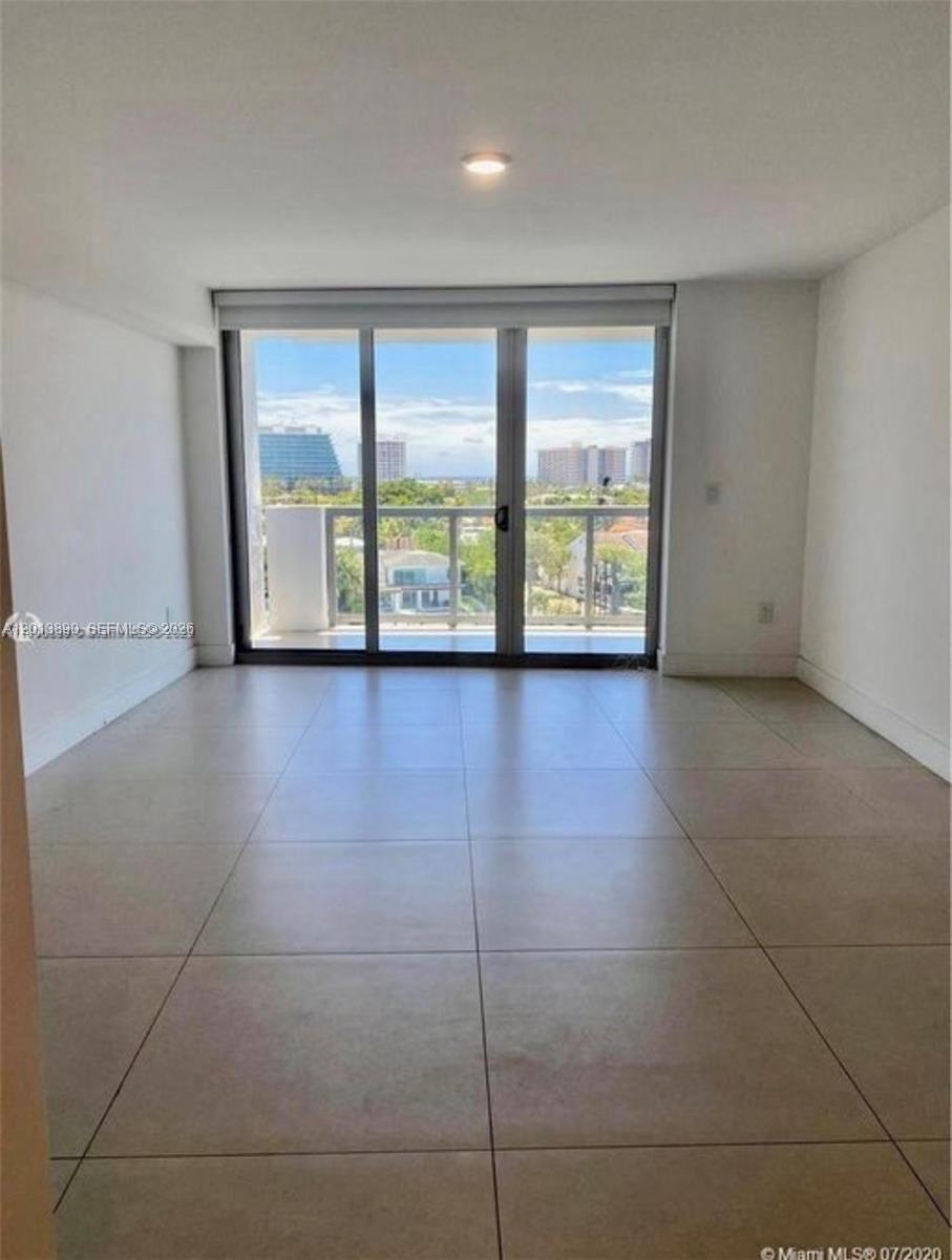 An empty room with large sliding glass doors leading to a balcony and tiled floors — 9261 E Bay Harbor Dr # 704, Bay Harbor Islands FL 33154, BAY HARBOR ISLANDS, FL