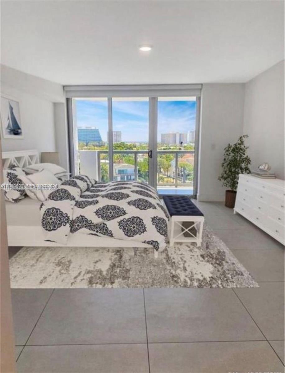 A bedroom features a bed with patterned bedding, a white dresser, and a balcony view — 9261 E Bay Harbor Dr # 704, Bay Harbor Islands FL 33154, BAY HARBOR ISLANDS, FL