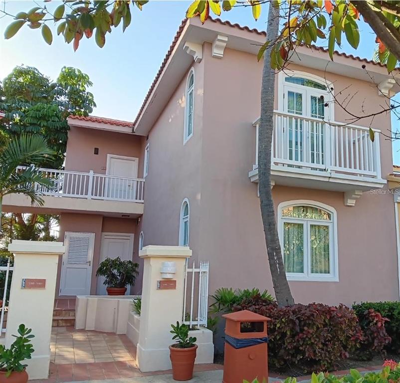 A two-story pink stucco building features white railings, arched windows, and a tiled entryway — LAS CASITAS VILLAGE 1 1 AVE CONQUISTADOR UNIT 5393, FAJARDO, PR