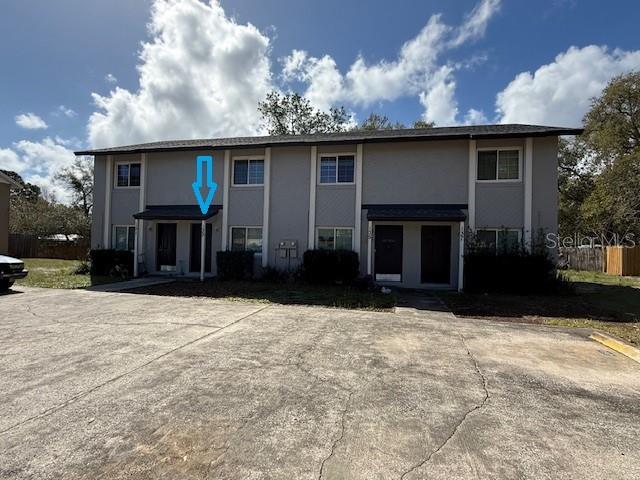 A two-story multi-unit residential building with a concrete parking lot in the foreground — 133 GARDEN DRIVE, WINTER SPRINGS, FL