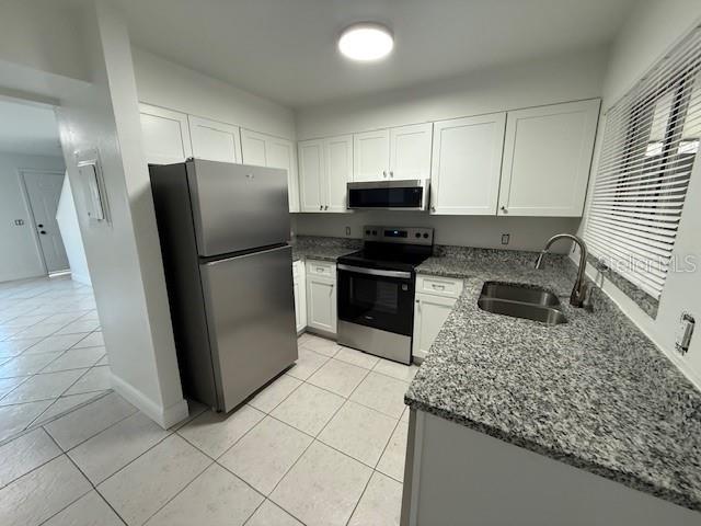 A kitchen features stainless steel appliances, white cabinets, and granite countertops — 133 GARDEN DRIVE, WINTER SPRINGS, FL