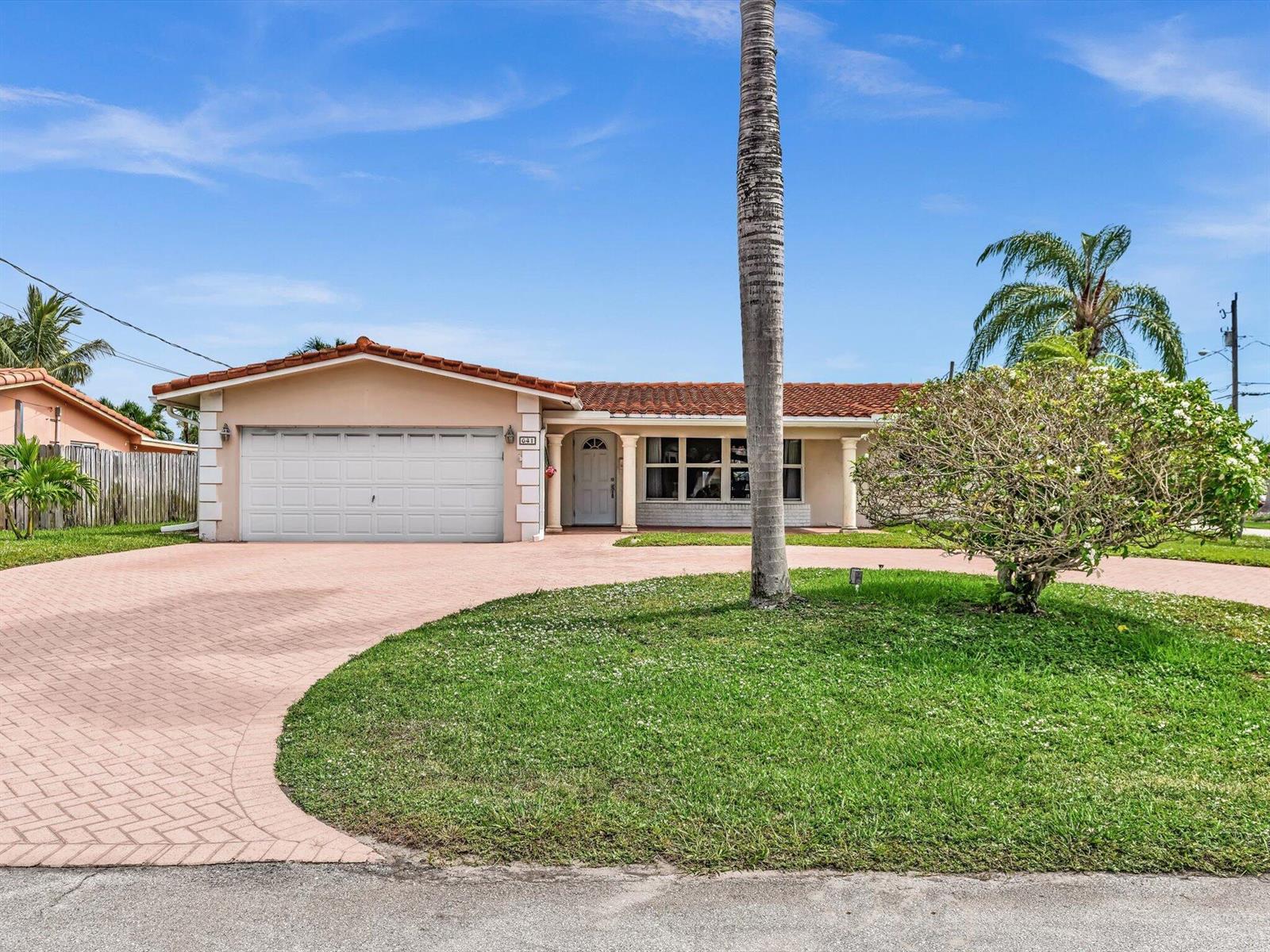 A single-story house with a tiled roof, white garage door, and a circular paved driveway — 641 SE 11th Street, Pompano Beach FL 33060, POMPANO BEACH, FL