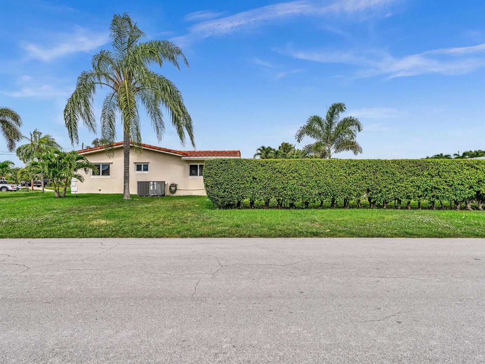 A single-story house with a red tile roof sits behind a tall, manicured green hedge — 641 SE 11th Street, Pompano Beach FL 33060, POMPANO BEACH, FL