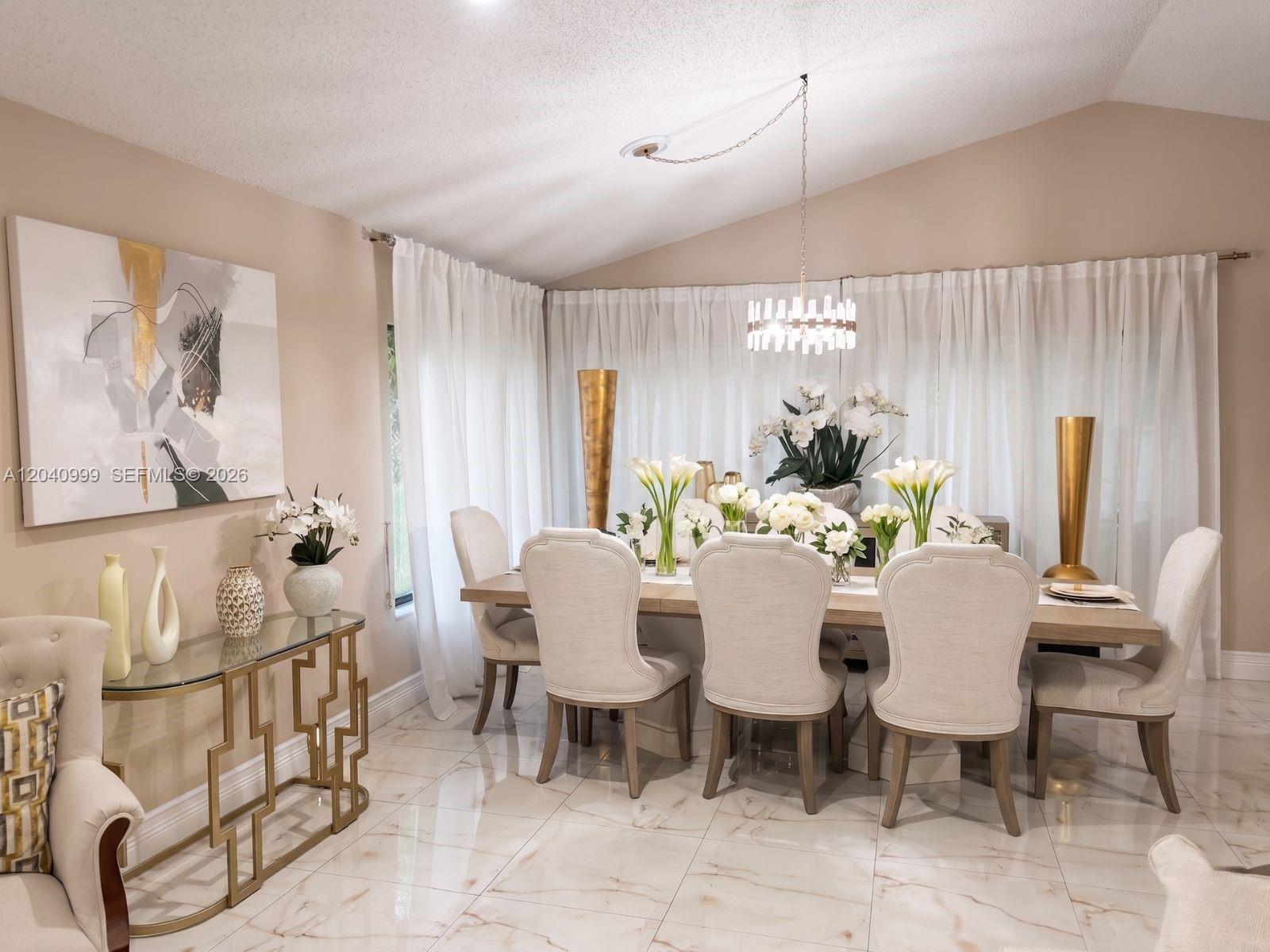 A dining room features a long table with upholstered chairs, a chandelier, and marble flooring — 324 Patio Village Ter, Weston FL 33326, WESTON, FL