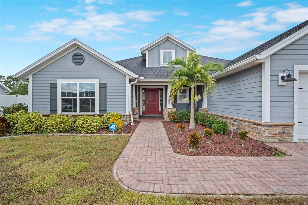 A single-story house with gray siding, a red front door, and a brick walkway — 510 CODY ALLEN COURT, ST CLOUD, FL
