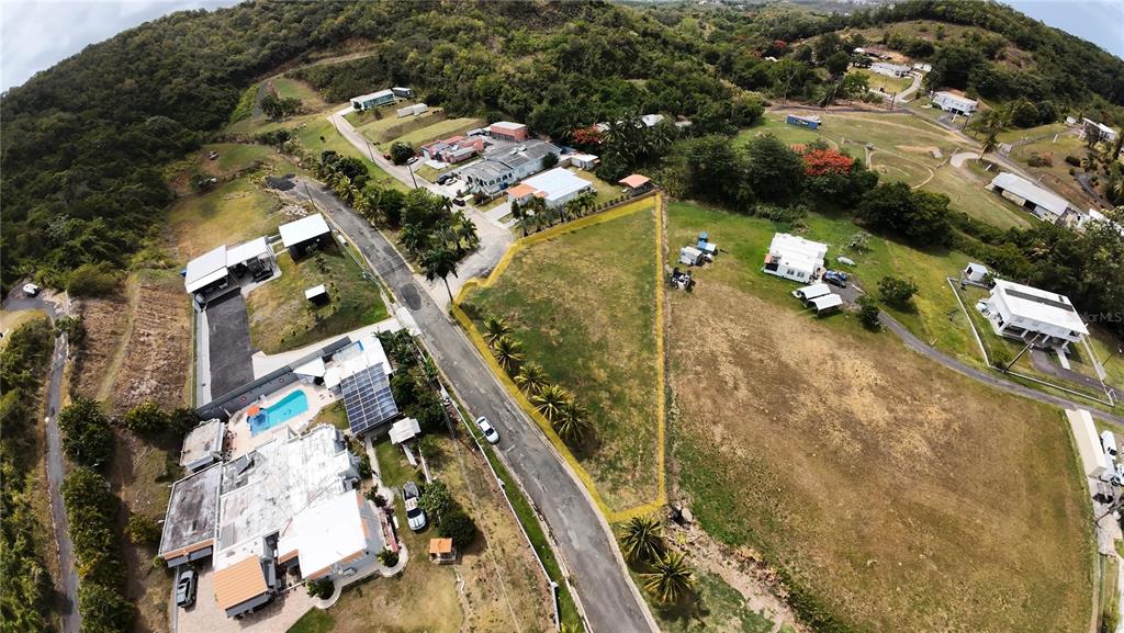 An aerial view shows a vacant, triangular-shaped lot bordered by a road and grassy fields — PR 985 QUEBRADA FAJARDO UNIT 4F, FAJARDO, PR