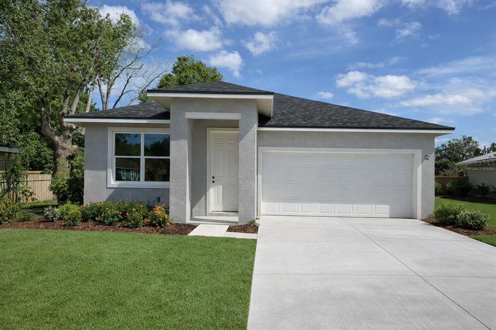 A single-story house with a gray stucco exterior, a white garage door, and a front lawn — 4517 AMERICA STREET, ORLANDO, FL