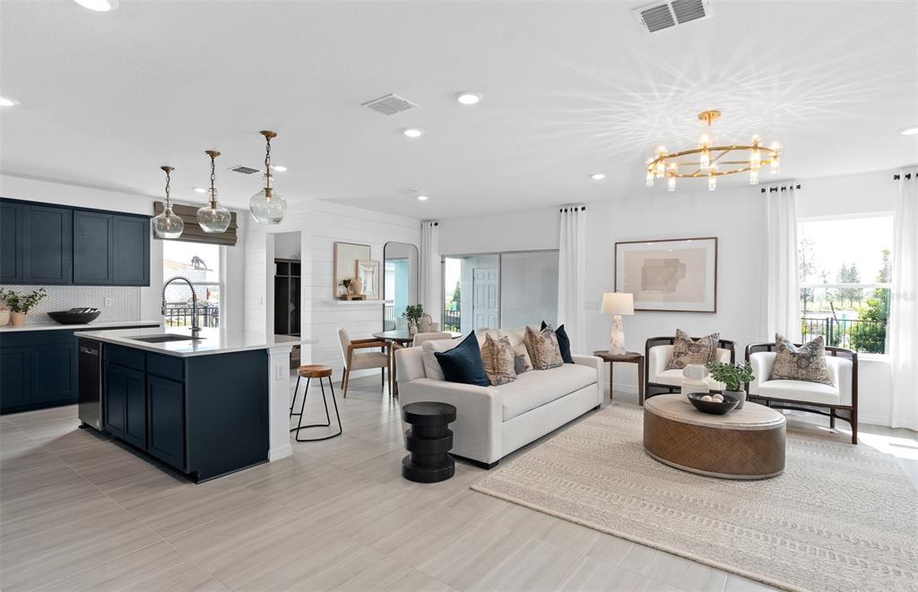 An open-concept living room and kitchen featuring dark blue cabinets and a light-colored sofa — 5093 STARLING BIRD LANE, ST CLOUD, FL