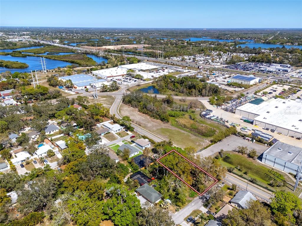An aerial view shows a rectangular vacant lot outlined in red near a commercial area — BOSTON STREET, TARPON SPRINGS, FL