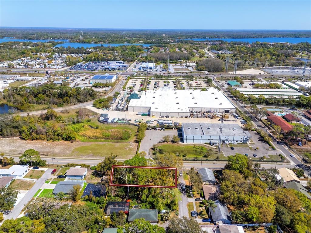 An aerial view shows a rectangular, tree-covered lot outlined in red within a residential neighborhood — BOSTON STREET, TARPON SPRINGS, FL