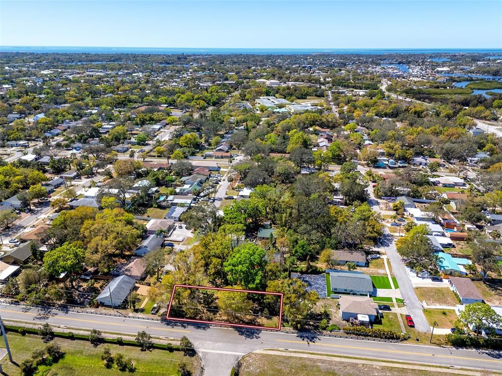 An aerial view shows a rectangular vacant lot outlined in red along a paved road — BOSTON STREET, TARPON SPRINGS, FL