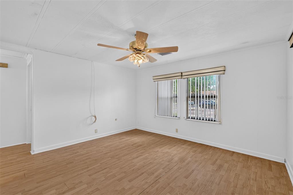 An empty room with white walls, wood-look flooring, a ceiling fan, and two windows — 304 ERON WAY UNIT 2, WINTER GARDEN, FL