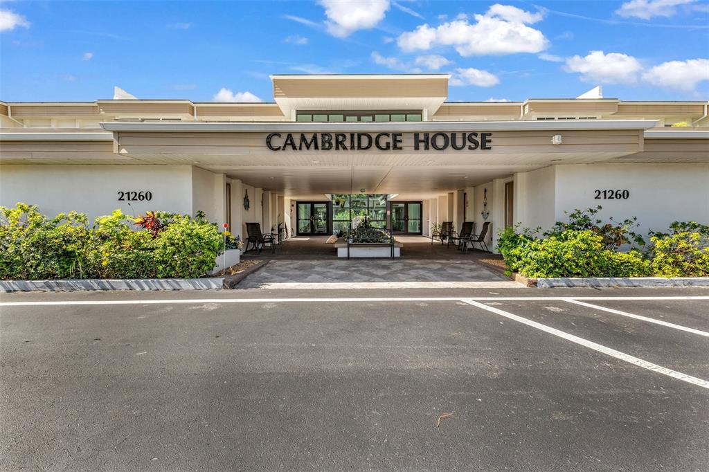 The exterior of a building entrance features a covered walkway with the name Cambridge House — 21260 BRINSON AVENUE UNIT 303, PORT CHARLOTTE, FL