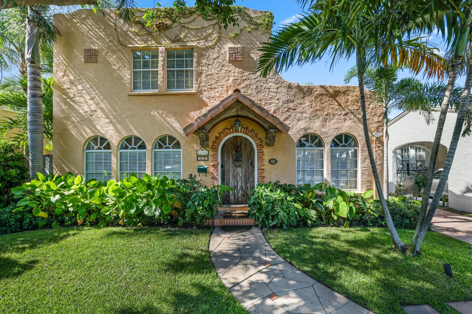 A two-story stucco house with a wooden arched front door and a stone walkway — 325 Greymon Drive, West Palm Beach FL 33405, WEST PALM BEACH, FL