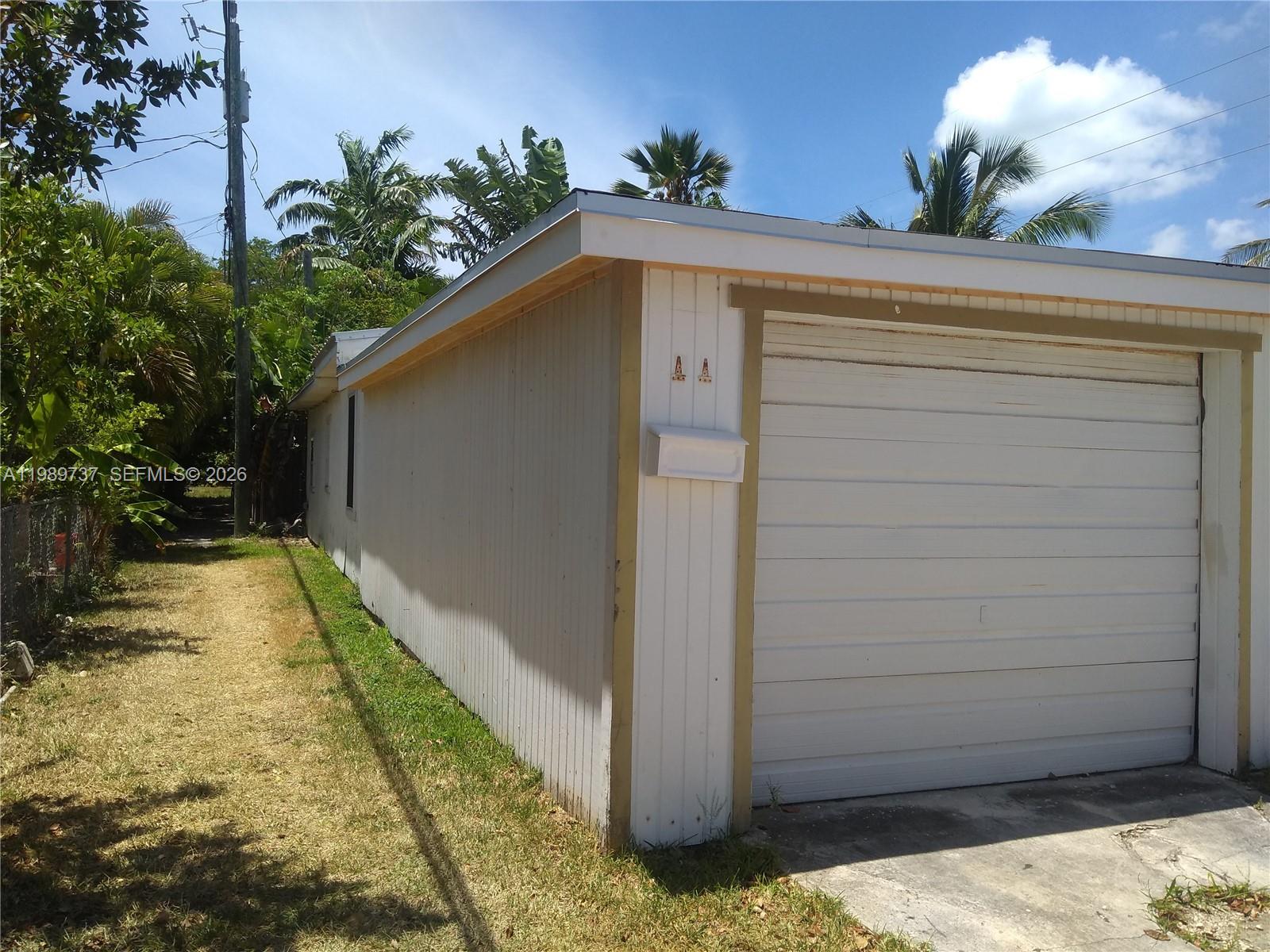 A white detached garage with a roll-up door sits on a grassy lot — 2330 Staples ave, Key West FL 33040, KEY WEST, FL