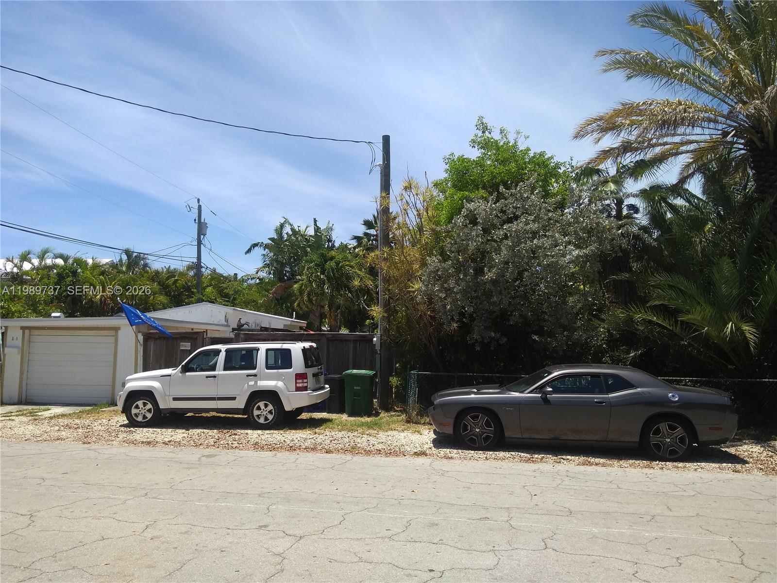 A white SUV and a gray coupe are parked on a gravel lot outdoors — 2330 Staples ave, Key West FL 33040, KEY WEST, FL