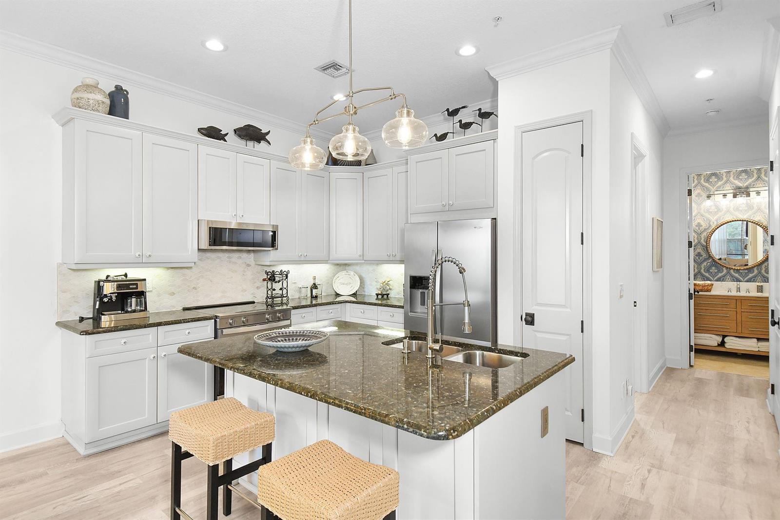 A kitchen with white cabinets, a dark granite island, and stainless steel appliances — 126 Ocean Bay Drive # 126, Jensen Beach FL 34957, JENSEN BEACH, FL