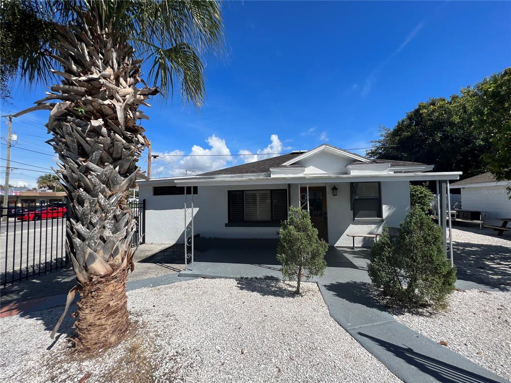 A white single-story house with a palm tree, gravel yard, and a covered front porch — 2323 W AILEEN STREET Bldg 2, TAMPA, FL