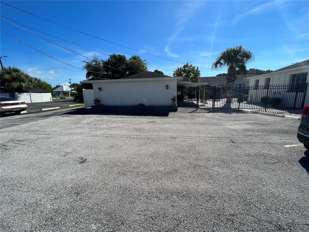 A paved parking lot sits in front of a white building with a black fence — 2323 W AILEEN STREET Bldg 2, TAMPA, FL