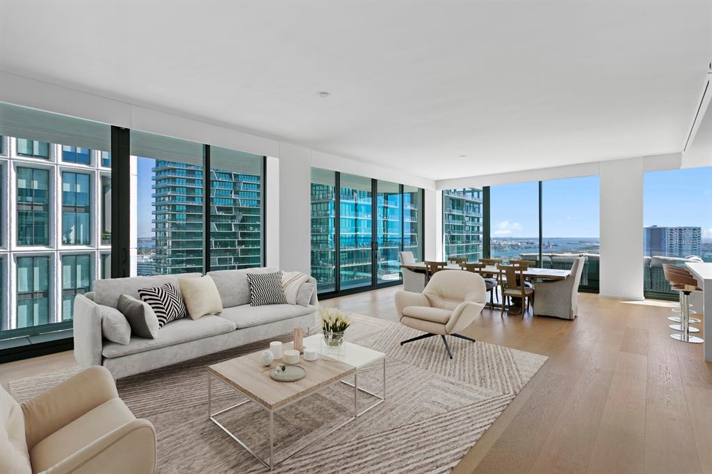 A modern living and dining room with floor-to-ceiling windows, light wood floors, and city views — 1000 WATER STREET UNIT 1502, TAMPA, FL