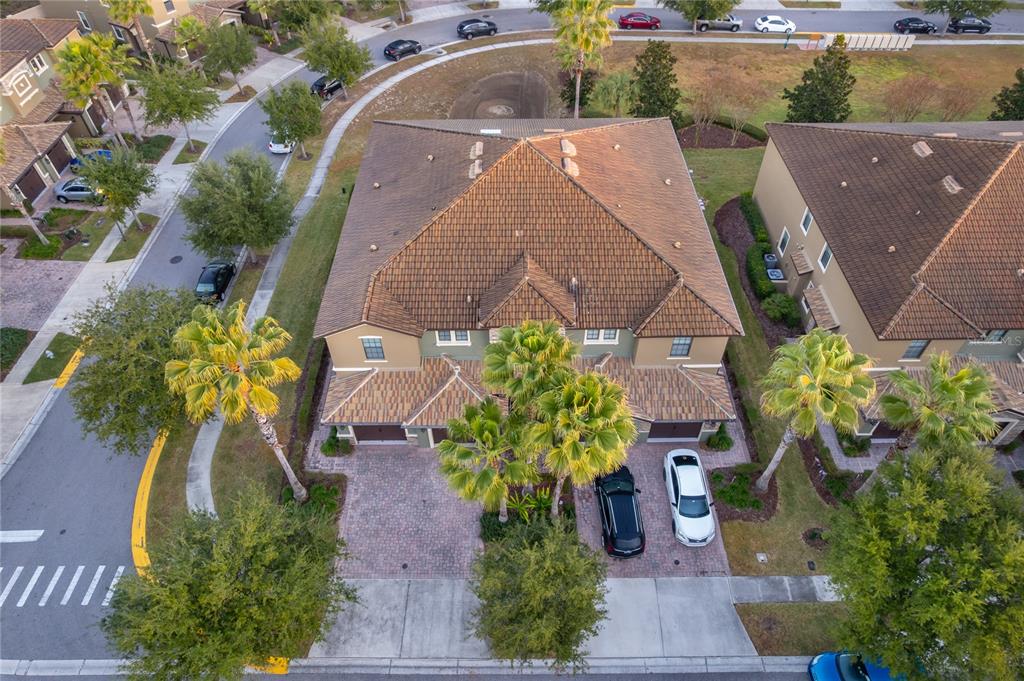 An aerial view shows a two-story townhouse with a tiled roof and a paved driveway — 8945 AZALEA SANDS LANE UNIT 8945, CHAMPIONS GATE, FL