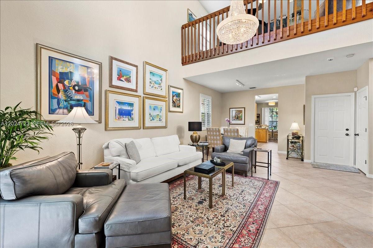 A living room features a white sofa, gray leather chairs, a patterned rug, and a chandelier — 1241 Grant St, Hollywood FL 33019, HOLLYWOOD, FL