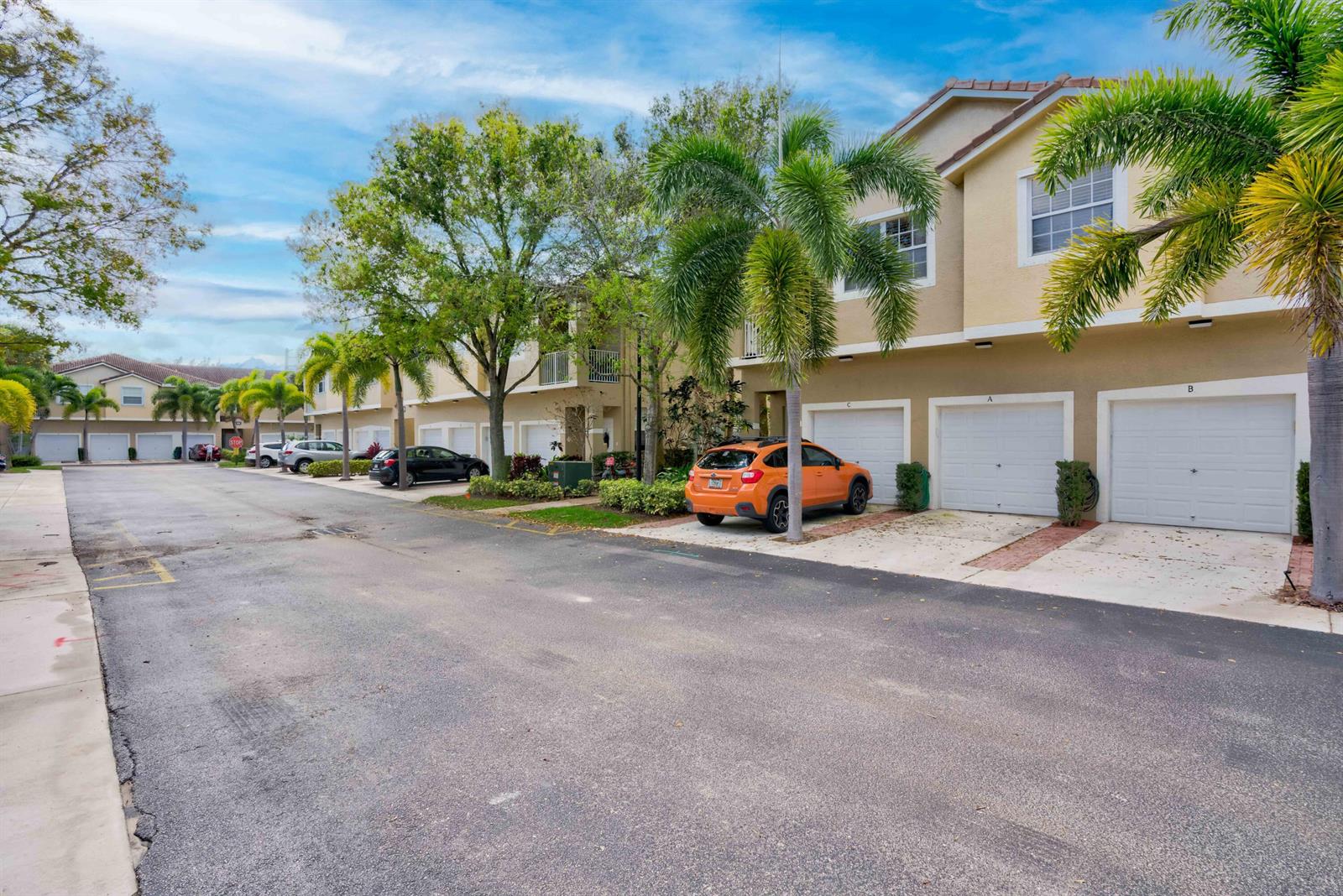 An exterior view of a residential townhouse complex with a street and parked cars — 115 Lighthouse Circle # B, Tequesta FL 33469, TEQUESTA, FL