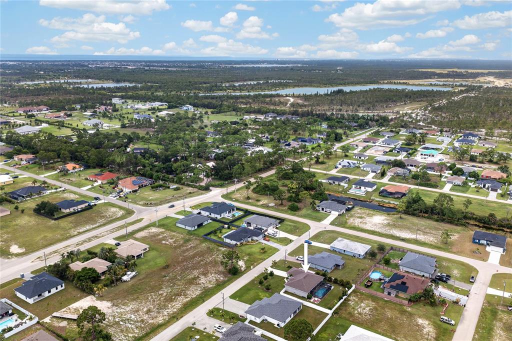 An aerial view shows a suburban neighborhood with single-family homes and a marked property — 2909 NW 24TH AVENUE, CAPE CORAL, FL