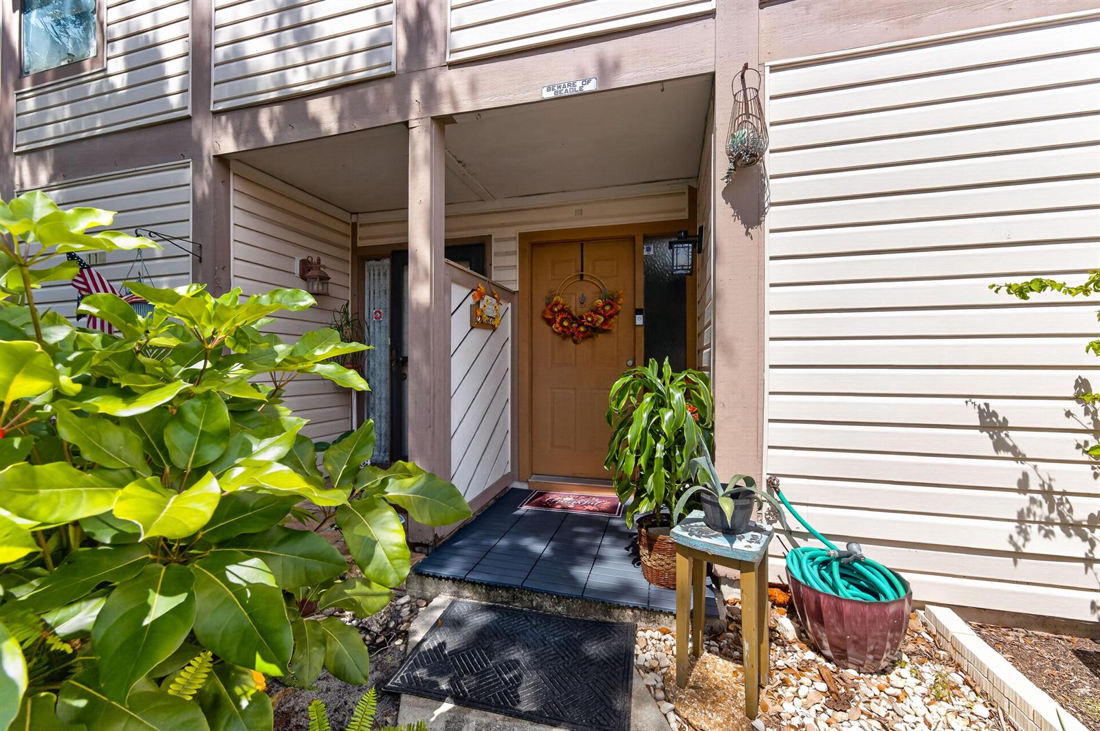 The exterior view shows a tan front door with a wreath under a covered porch — 124 Sherwood Circle # 11b, Jupiter FL 33458, JUPITER, FL
