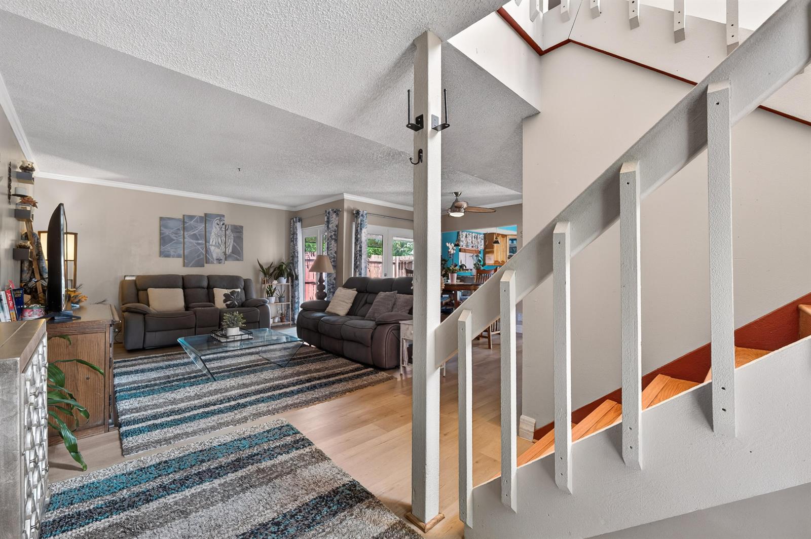 A living room with gray sofas, a striped rug, and a staircase with white railings — 124 Sherwood Circle # 11b, Jupiter FL 33458, JUPITER, FL