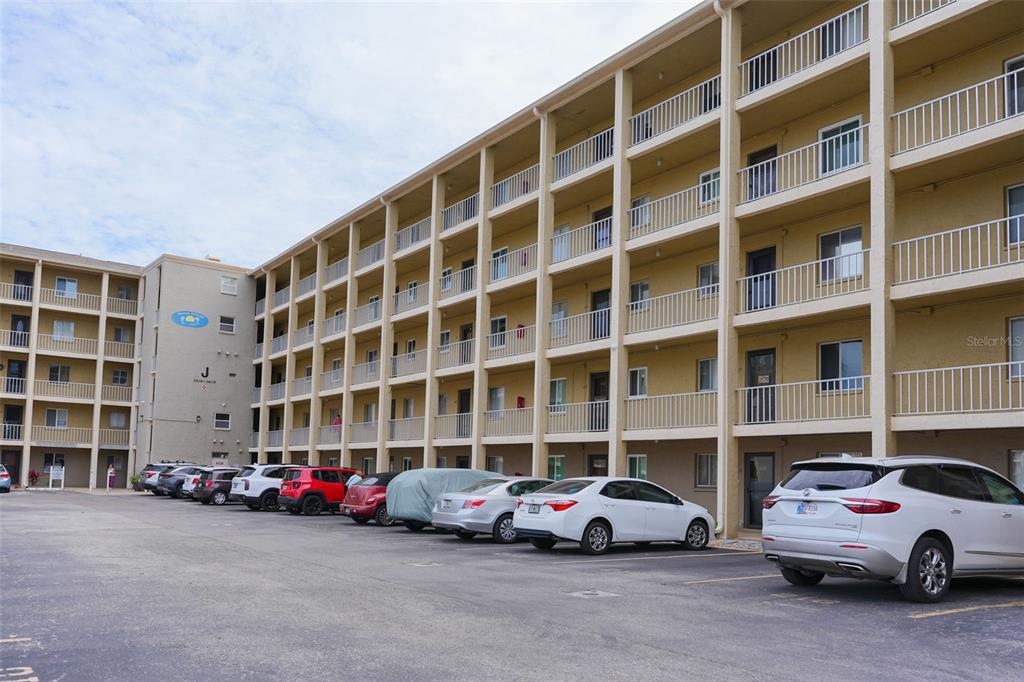 A multi-story apartment building with exterior walkways and a parking lot in the foreground — 3607 LAKE BAYSHORE DRIVE UNIT 312, BRADENTON, FL