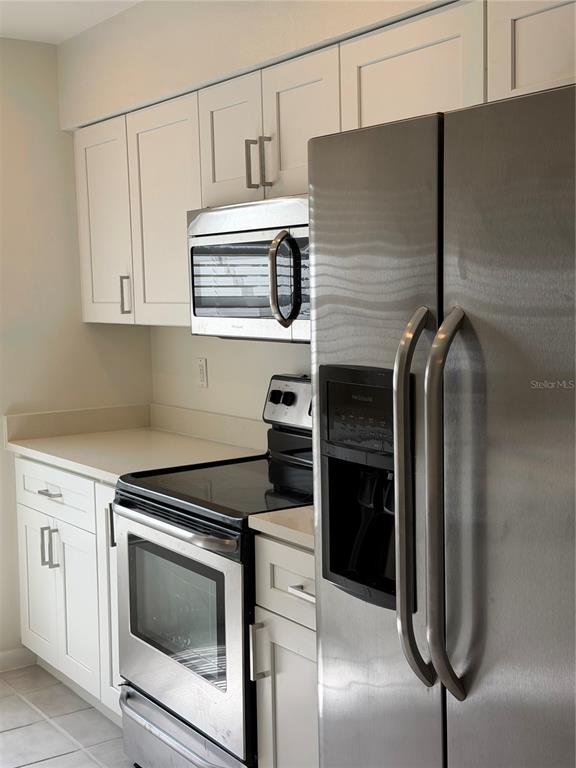 A kitchen features white cabinets, stainless steel appliances, and light-colored countertops — 518 BRYAN VALLEY COURT, BRANDON, FL