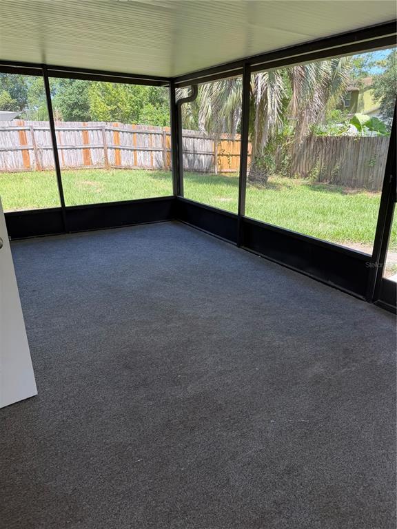 A screened-in porch with gray carpeting and a view of a fenced backyard — 518 BRYAN VALLEY COURT, BRANDON, FL